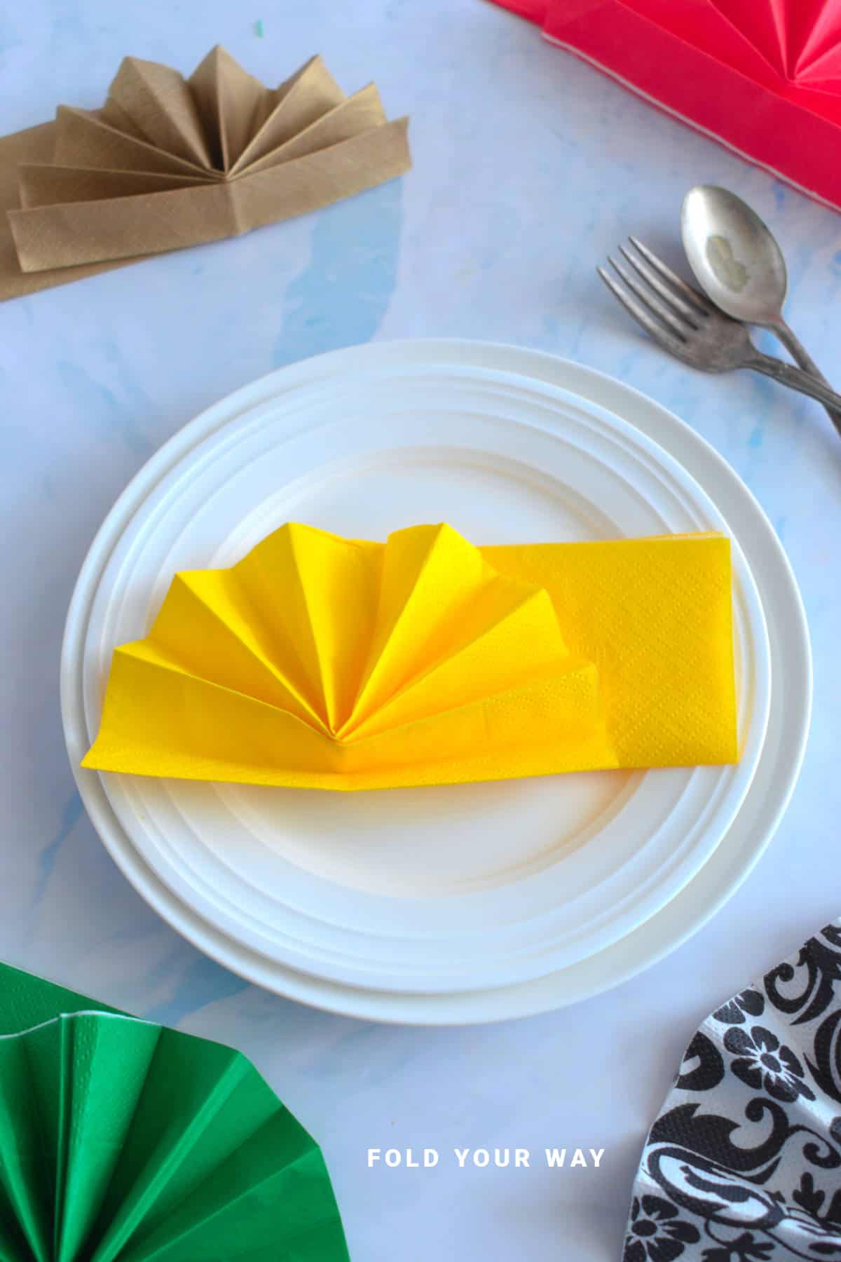 Yellow napkin folded on a plate.