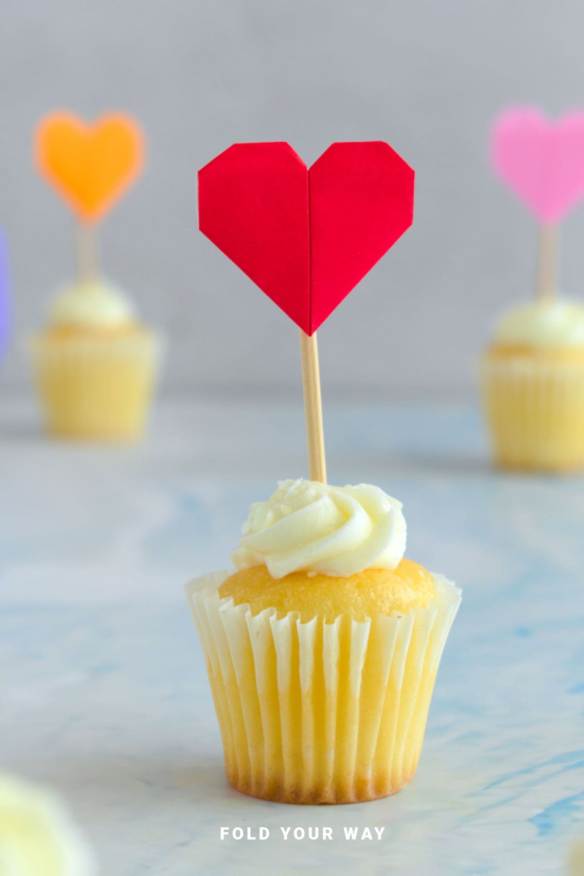 Red heart cake topper on a cupcake.