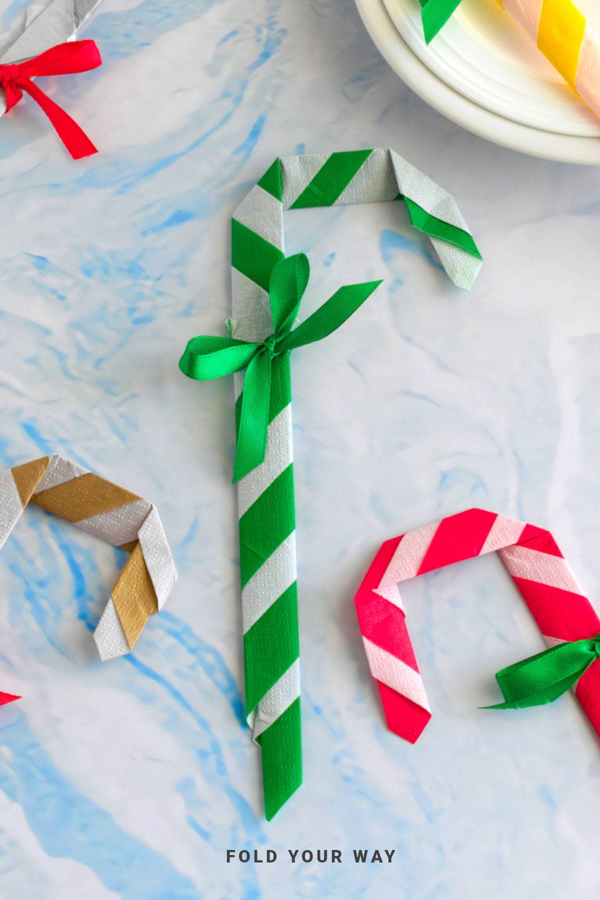 Green and white candy cane napkin fold.