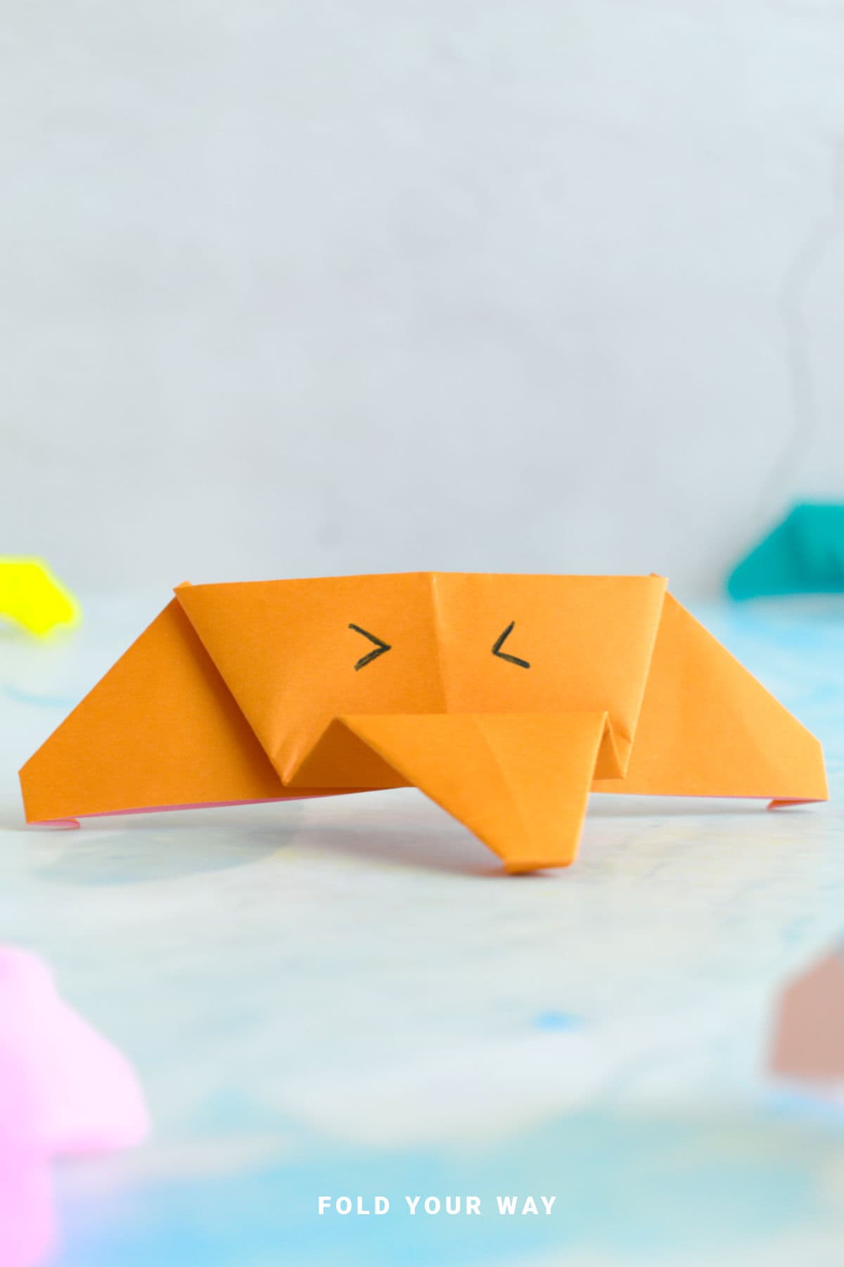 Orange origami elephant face.