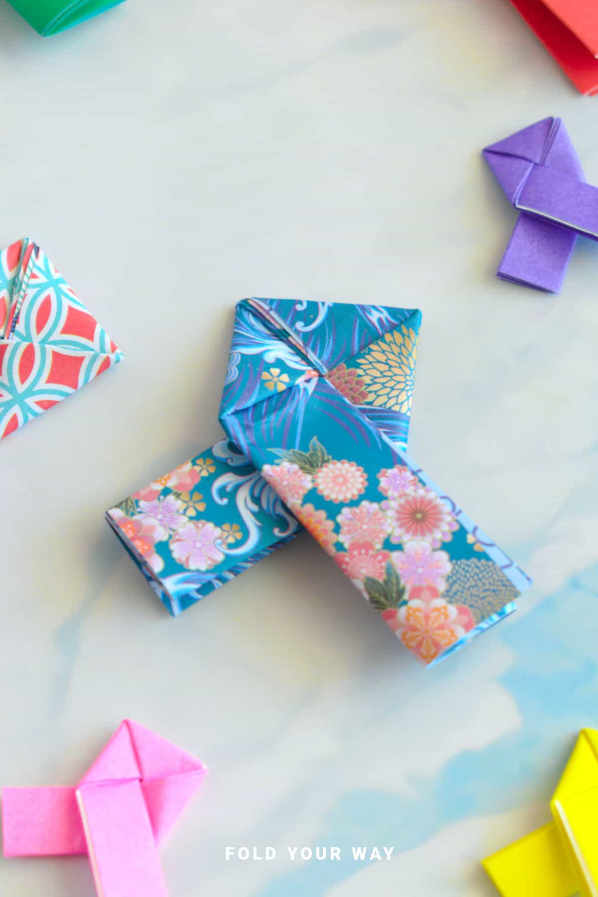 Blue and pink origami lovers knot.