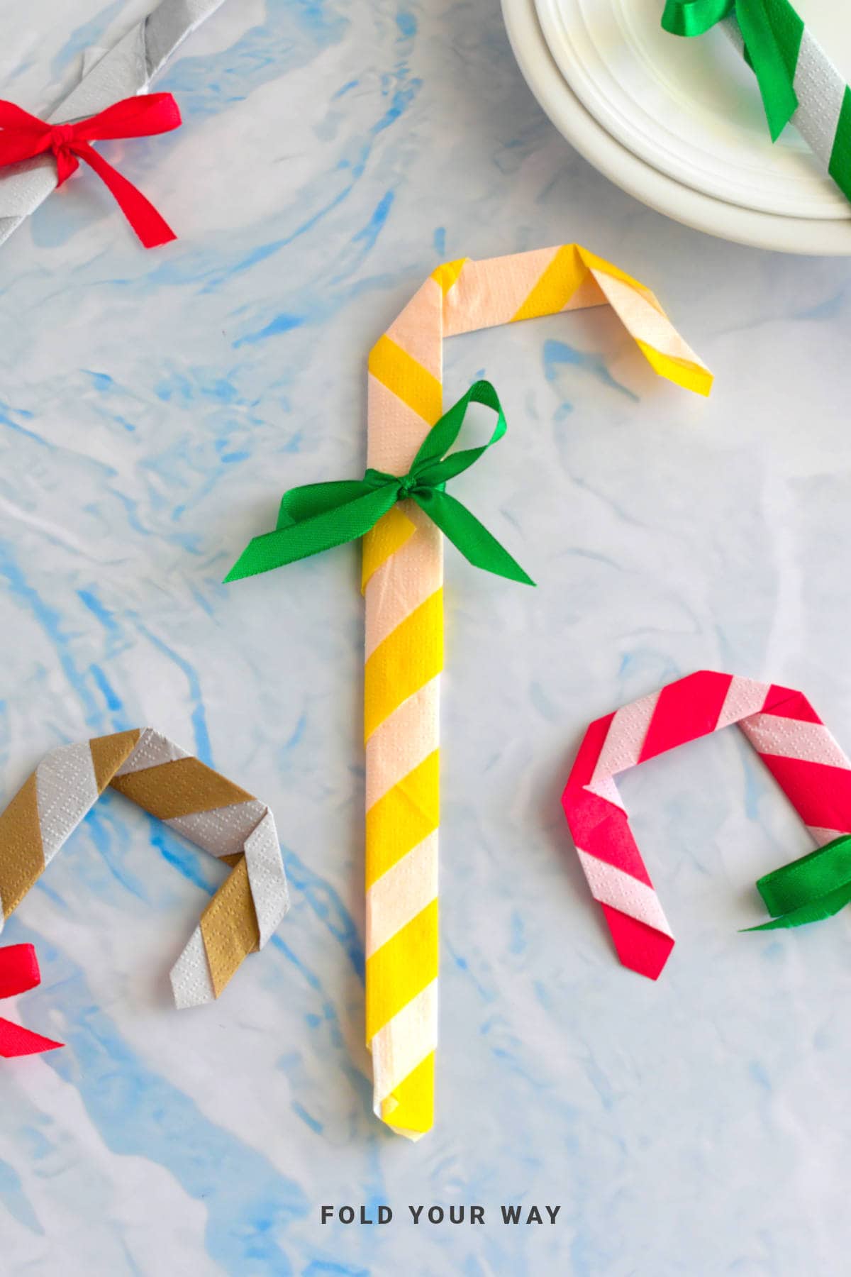 Yellow and white candy cane napkin fold.
