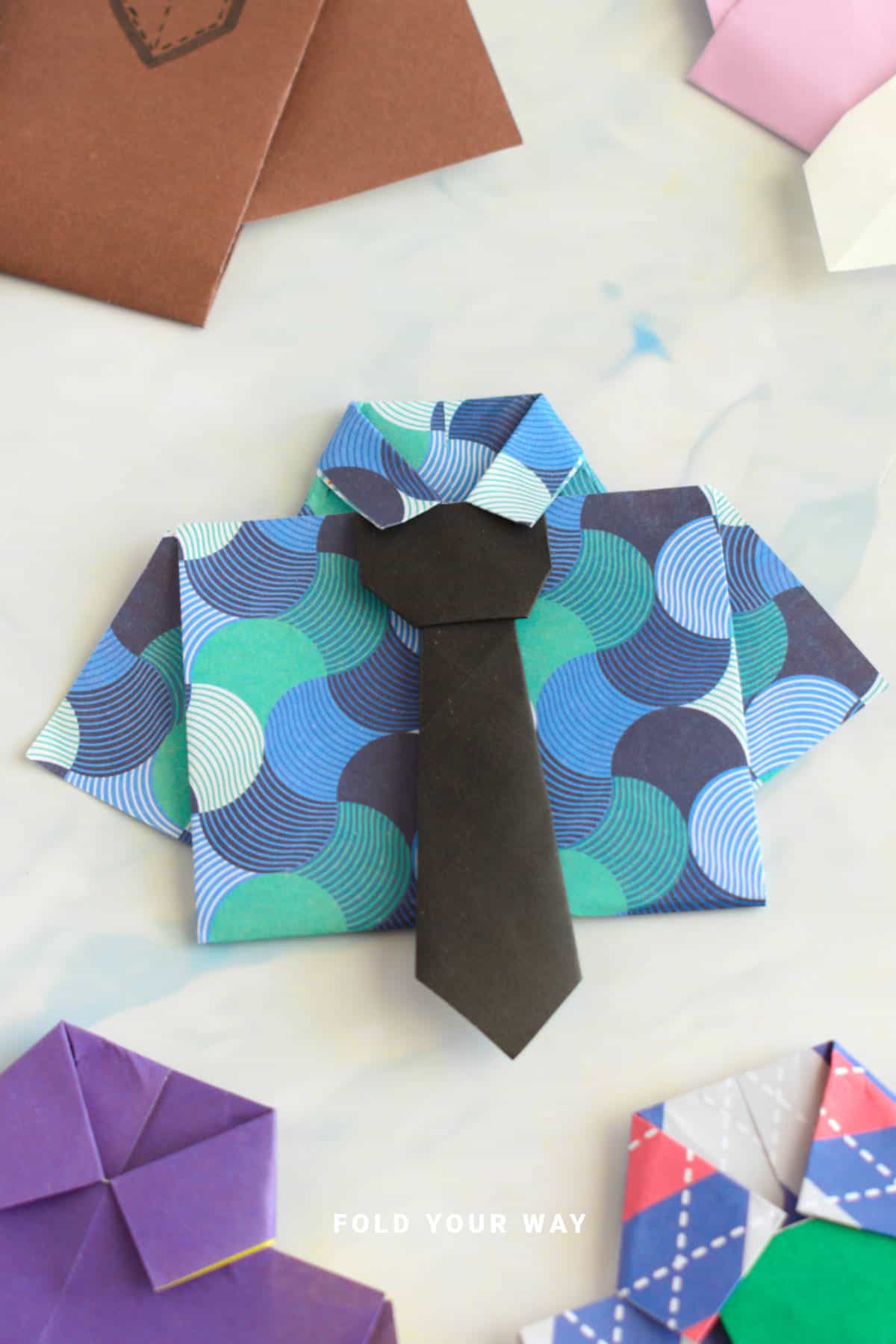 Blue and green origami shirt with black tie.