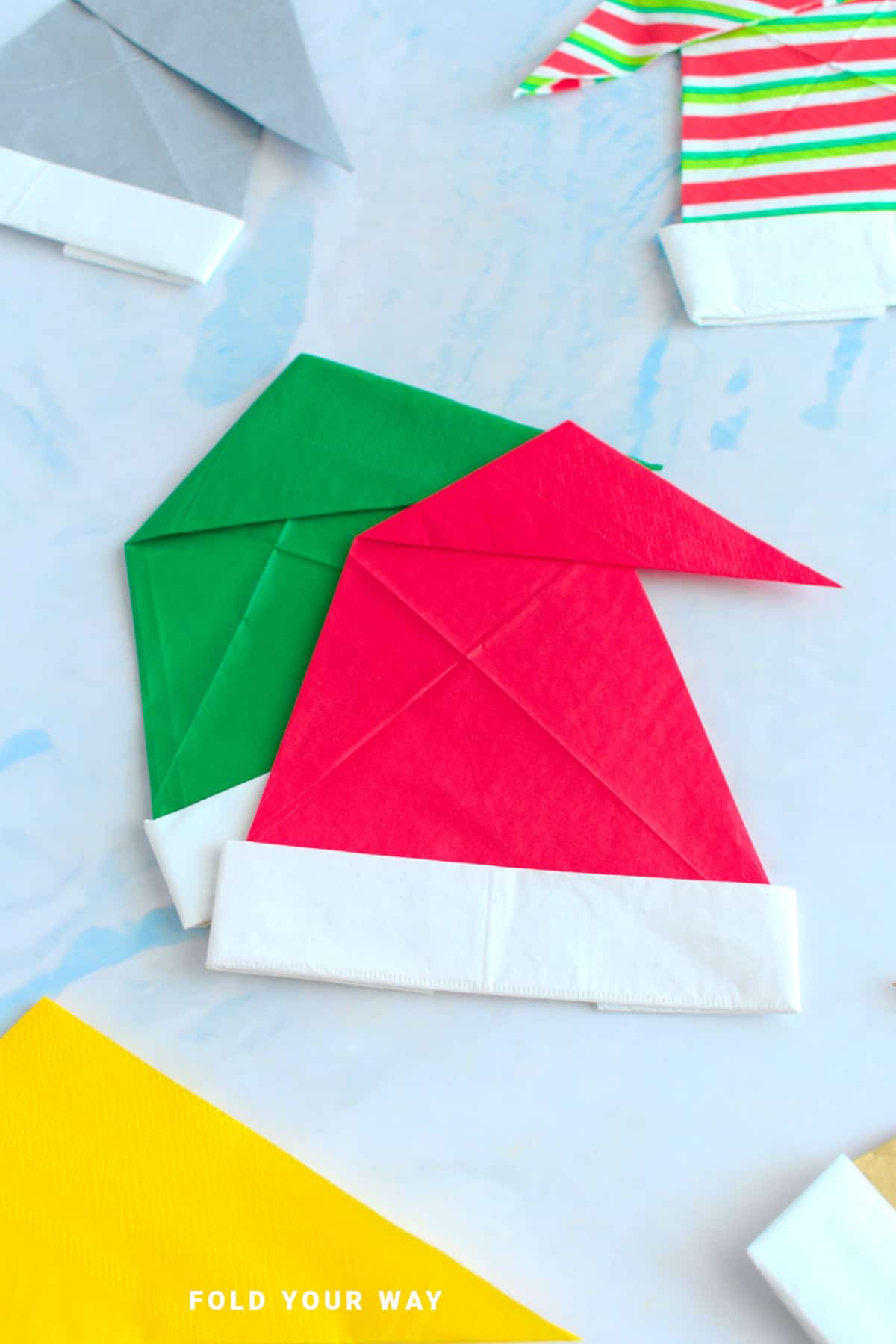 Red and green Santa hat napkin folds.