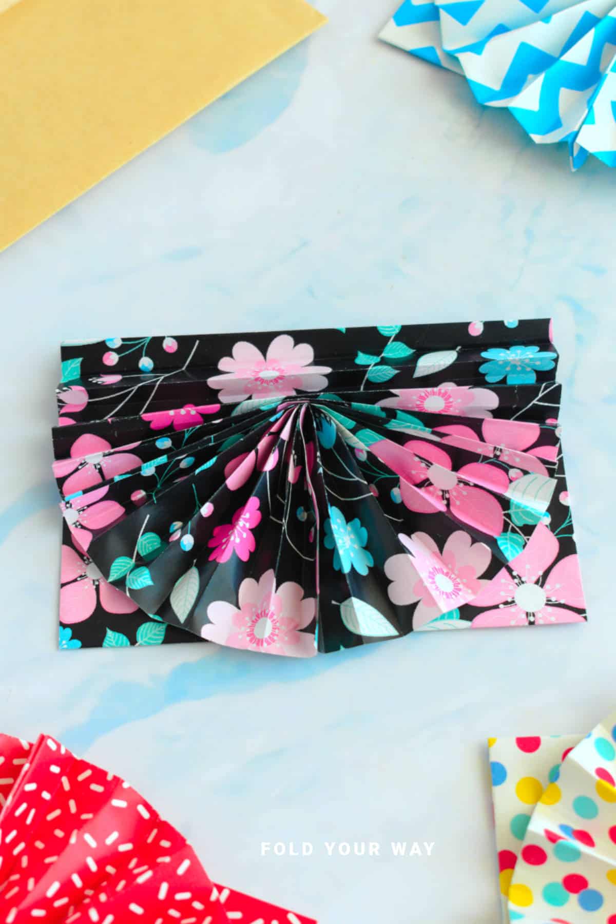 Black, blue, and pink envelope with fan.