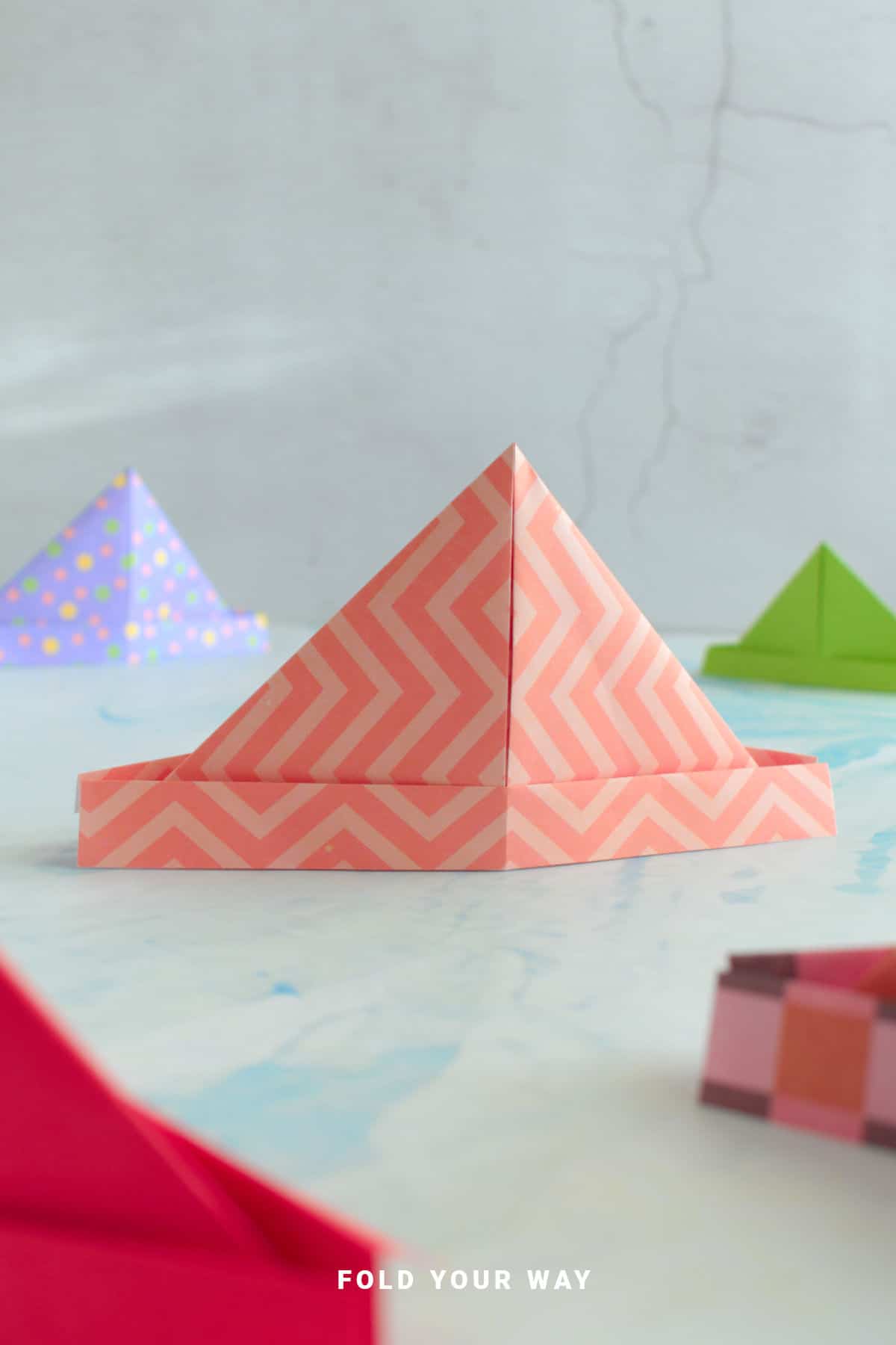 Pink striped origami hat.