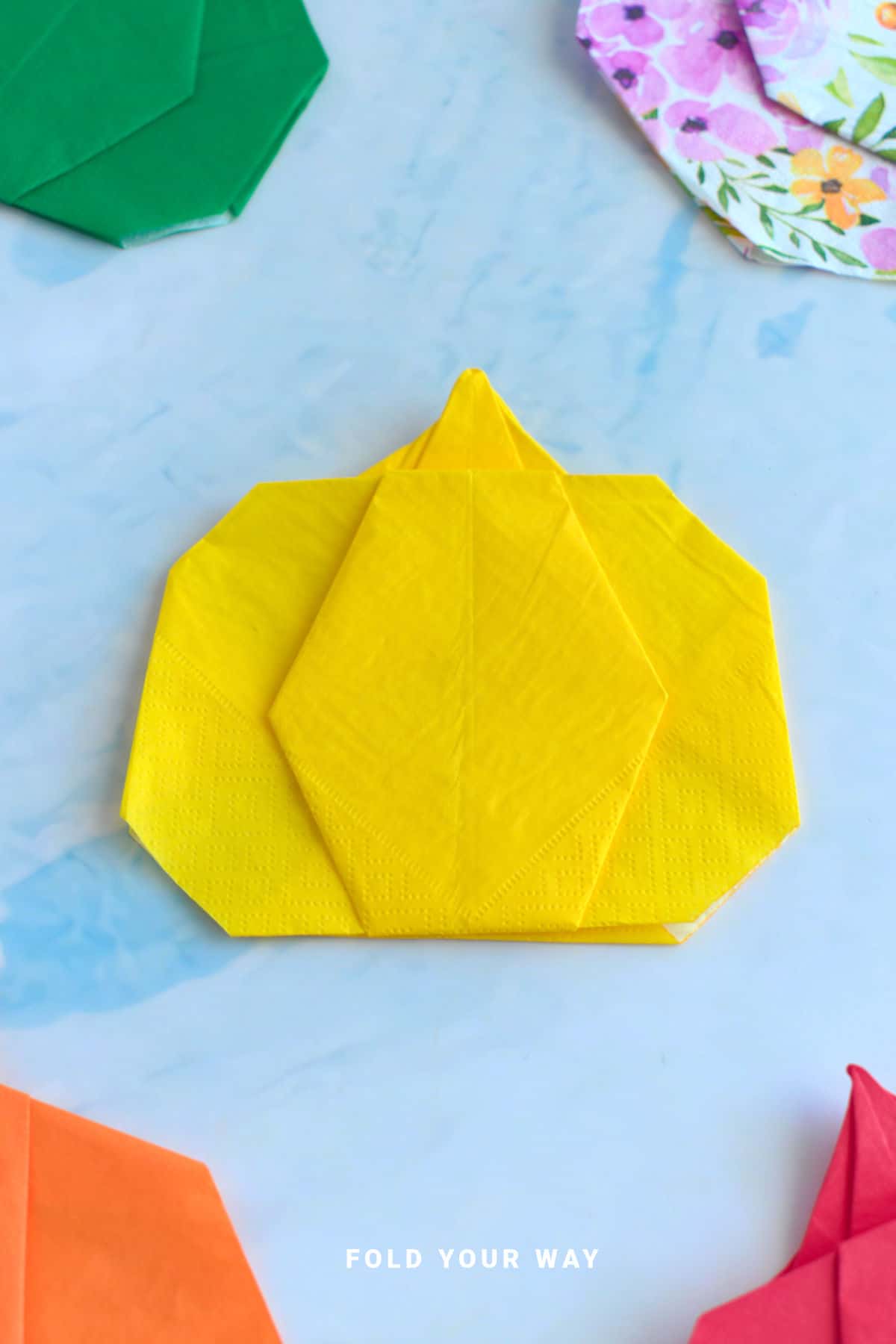 Yellow pumpkin napkin fold.
