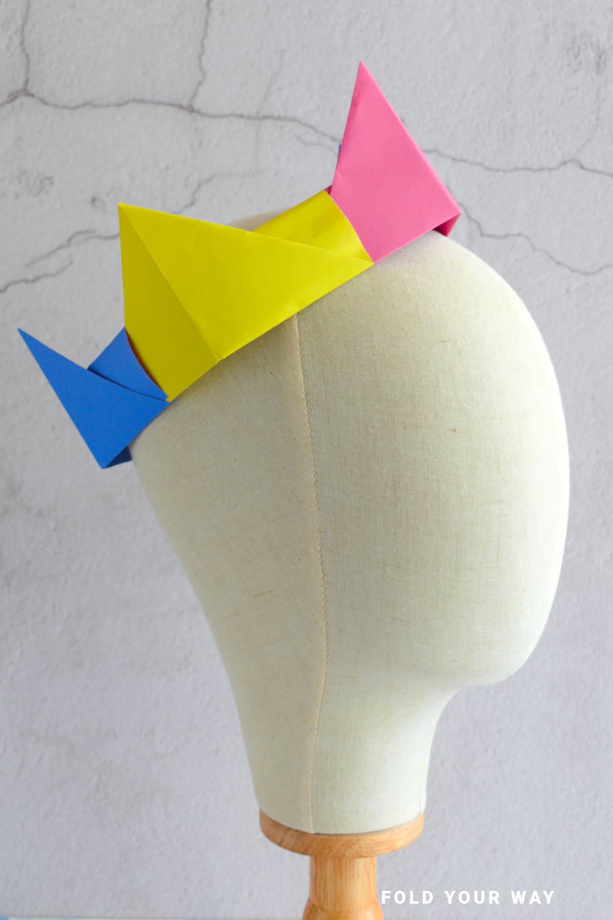Yellow, pink, and blue origami crown.